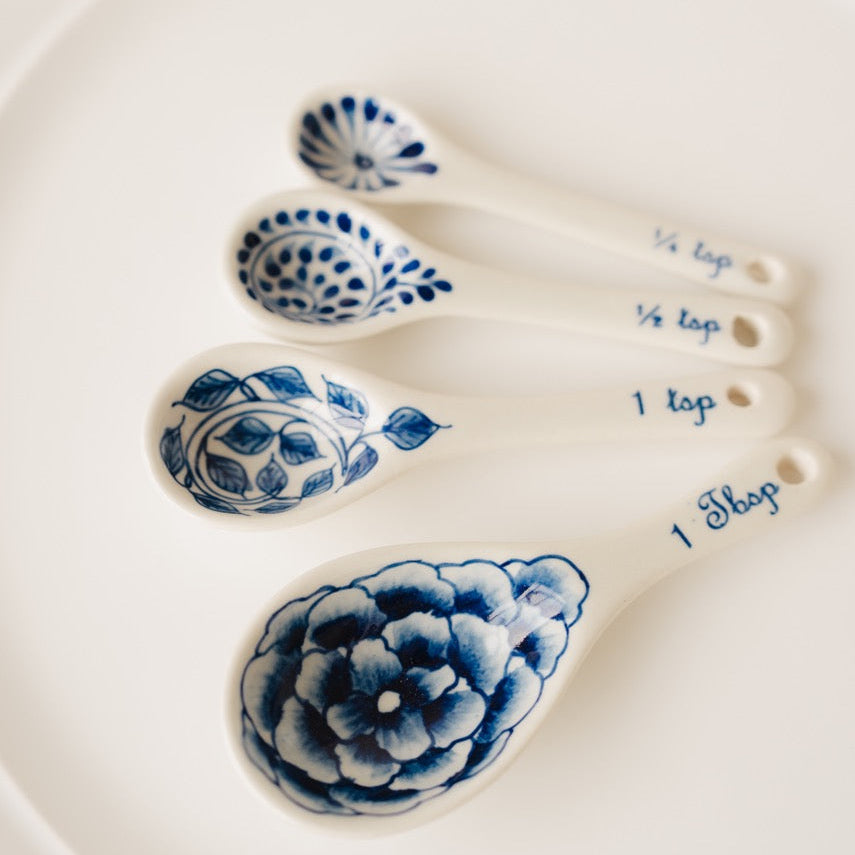 Set of blue and white ceramic measuring spoons on a white plate