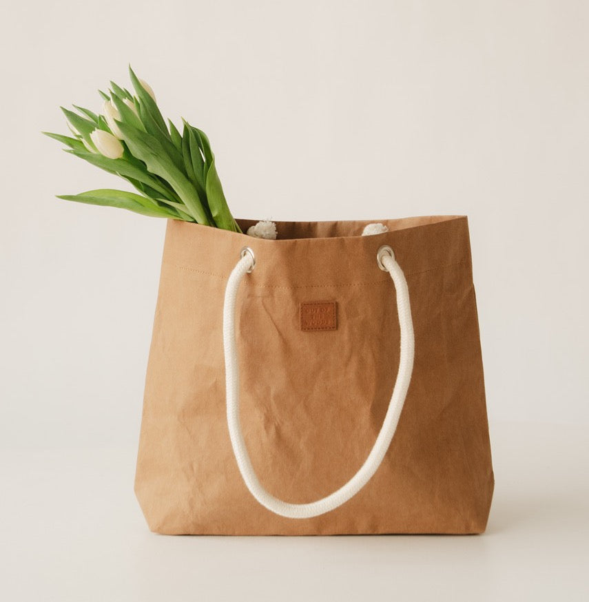 Brown tote bag with white handles and tulips on a light background